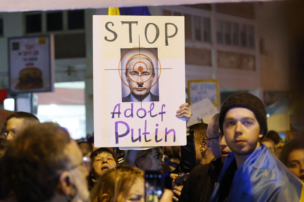Göstericiler, işgali protesto etmek için Tel Aviv'deki Rus Büyükelçiliği önünde pankartlar taşıyorlar. 
