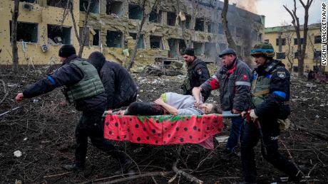 Ukraynalı acil servis personeli ve gönüllüler, 9 Mart 2022 Çarşamba, Mariupol, Ukrayna'daki bombalamada hasar gören bir doğum hastanesinden yaralı hamile bir kadını taşıyor. 