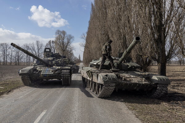 A Ukrainian solider atop a captured Russian tank in a village outside Kyiv on Sunday.