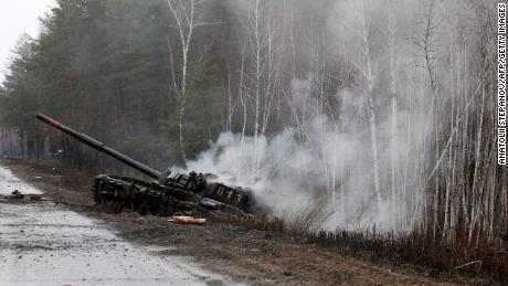 26 Şubat 2022'de Lugansk bölgesinde yol kenarında Ukrayna kuvvetleri tarafından tahrip edilen bir Rus tankından duman yükseliyor.