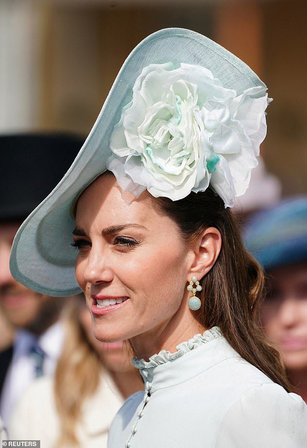 Kate Middleton dün Buckingham Sarayı'ndaki bir bahçe partisinde 140 sterlinlik akuamarin sallantılı küpe takarken görüntülendi (resimde)