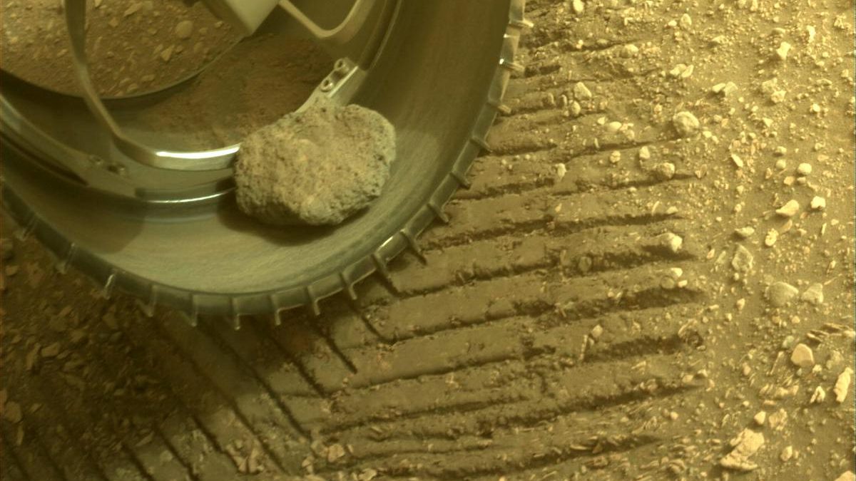 Sol ön tekerlekteki inatçı Mars gezgininin evcil kayasının yakından görünümü.