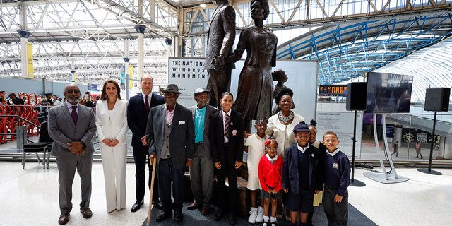 Prens William, Catherine, Cambridge Düşesi, Barones Floella Benjamin, sağda, Windrush yolcuları Alford Gardner, merkez, John Richards, soldan dördüncü ve Londra'daki Waterloo İstasyonu'nda Jamaikalı sanatçı Basil Watson tarafından yaratılan Windrush Ulusal Anıtı'ndaki çocuklar 22 Haziran 2022'de.