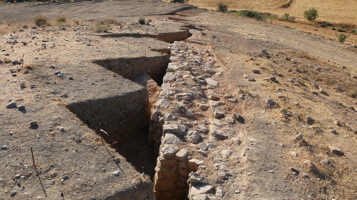 Kıbrıs'ta eski bir mezarlığın altına gizlenmiş kırık duvar.
