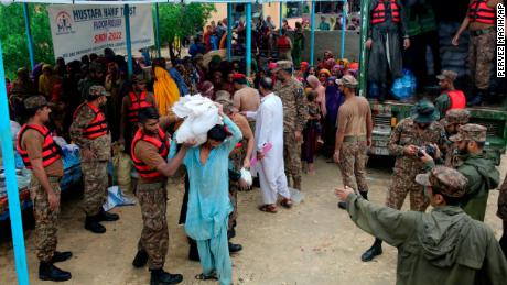 Ordu güçleri, 24 Ağustos'ta Pakistan'ın güneyindeki Jamshoro bölgesindeki bir yardım kampında yerinden edilmiş insanlara yiyecek ve malzeme dağıtıyor.