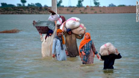 24 Ağustos'ta Pakistan'ın güneybatısındaki Belucistan eyaletinin bir bölgesi olan Caferabad'da yerinden edilmiş bir aile su basmış bir bölgede yüzüyor.