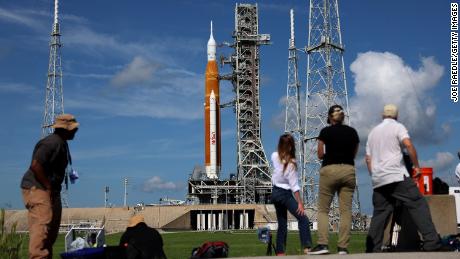 Fotoğrafçılar ve muhabirler Pazartesi günü Kennedy Uzay Merkezi'nde NASA'nın Artemis 1 roketinin yakınında çalışıyorlar.  Bir dizi sorun daha sonra önyüklemeyi engelledi.