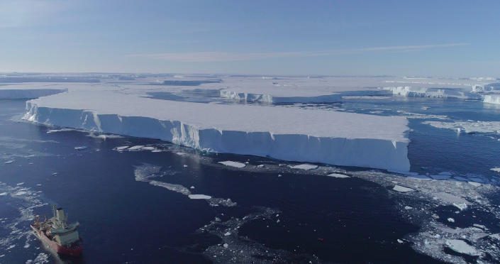 Antarktika'daki doğu Thwaites buz rafının kenarı boyunca suda bir araştırma gemisi.