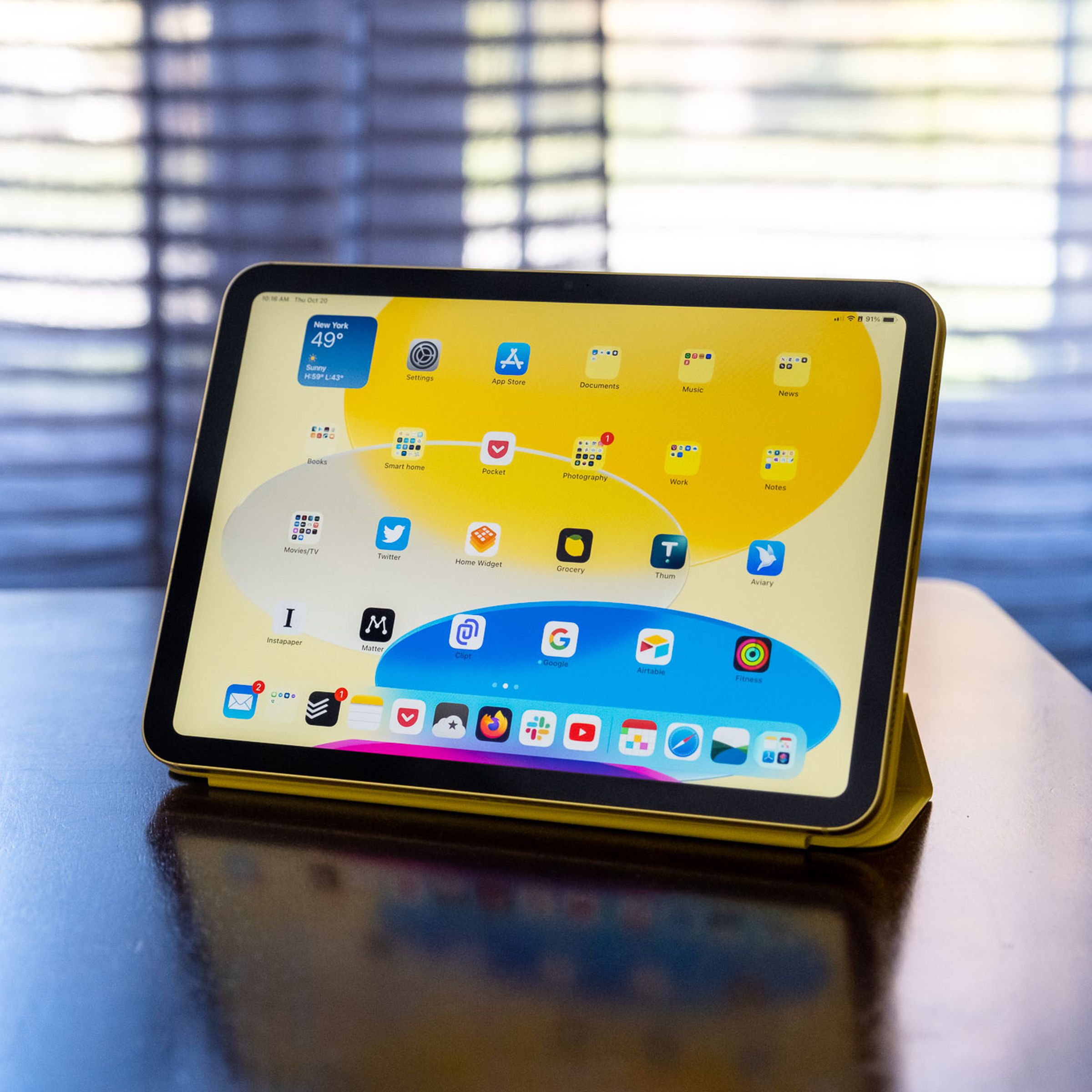 Ahşap bir masanın üzerindeki Apple Smart Folio'da 10. nesil bir iPad.