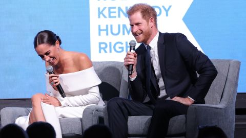 Çift, etkinlik sırasında sahnede Kerry Kennedy ile sohbet ederken gülüyor. 